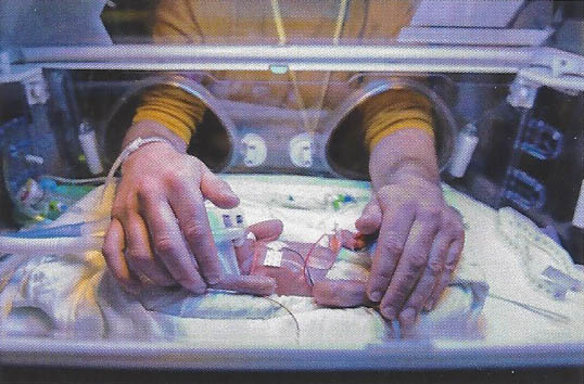 A baby in an enhanced technology bed